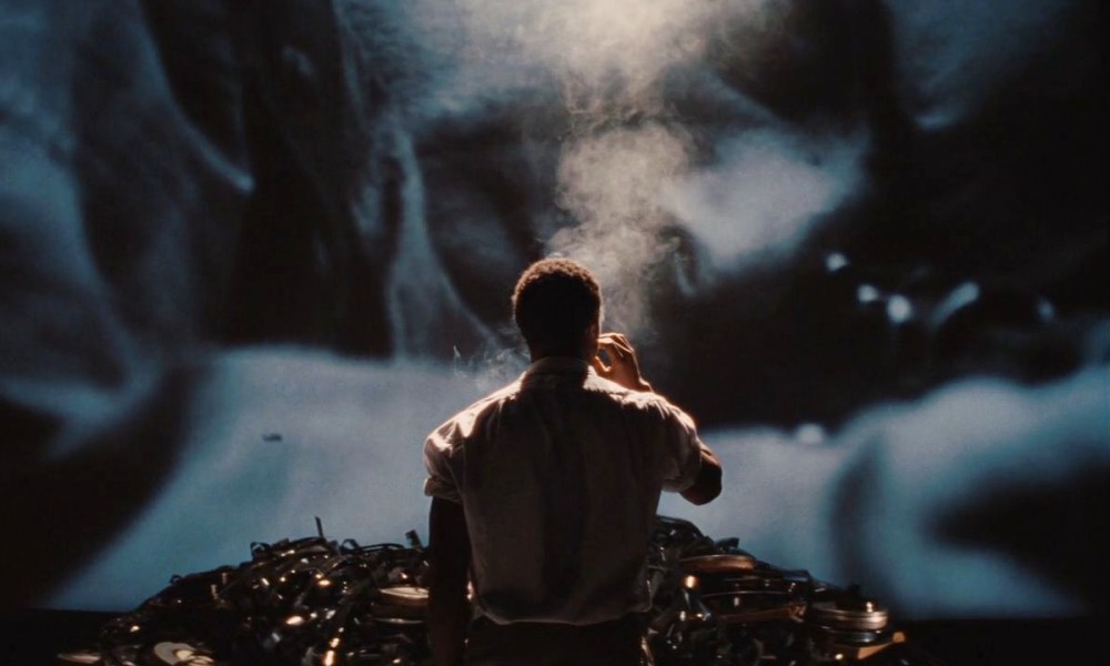 A man smokes in front of a pile of celluloid in Inglourious Basterds.