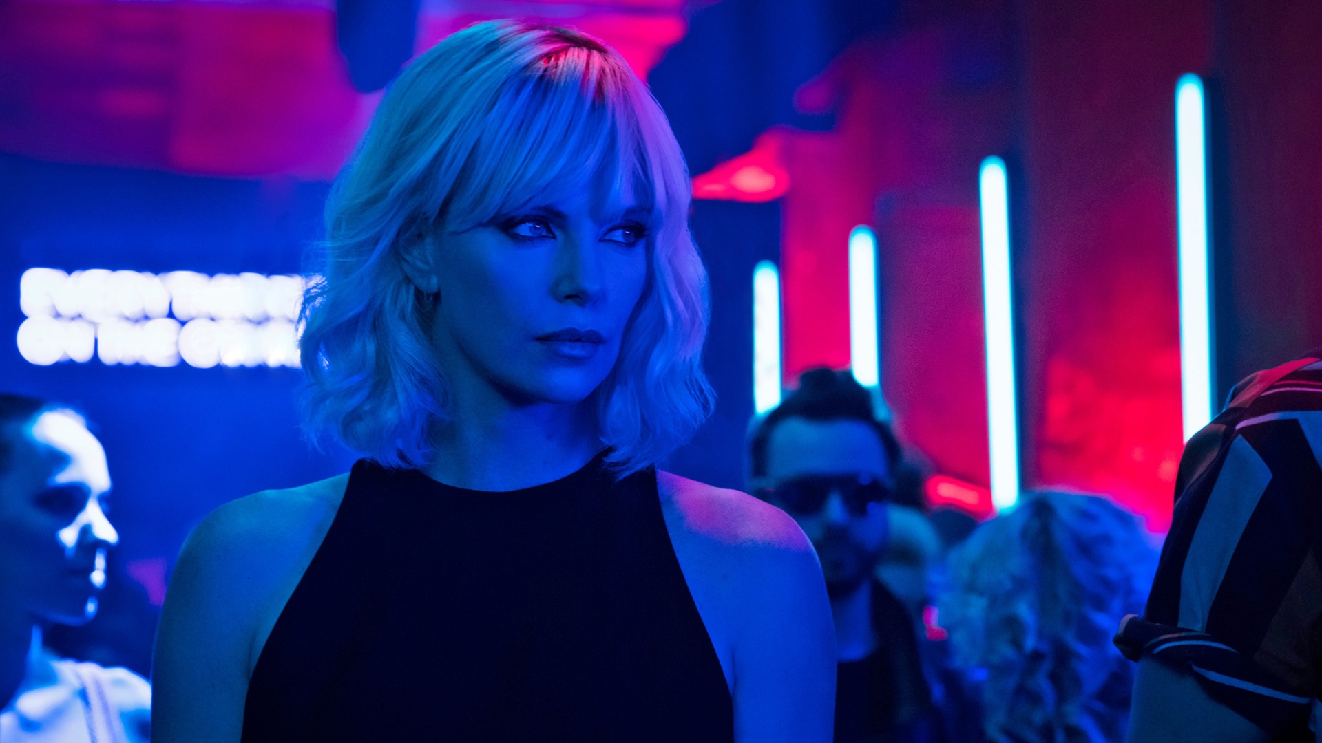 Charlize Theron als verdeckte Agentin in einem neonbeleuchteten Club in Atomic Blonde.