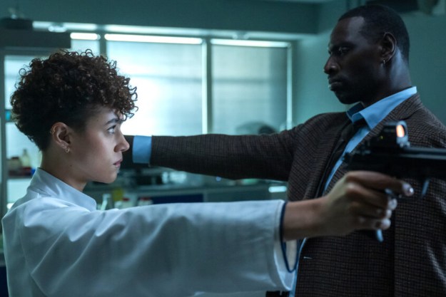 Nathalie Emmanuel and Omar Sy face each other with guns in The Killer.