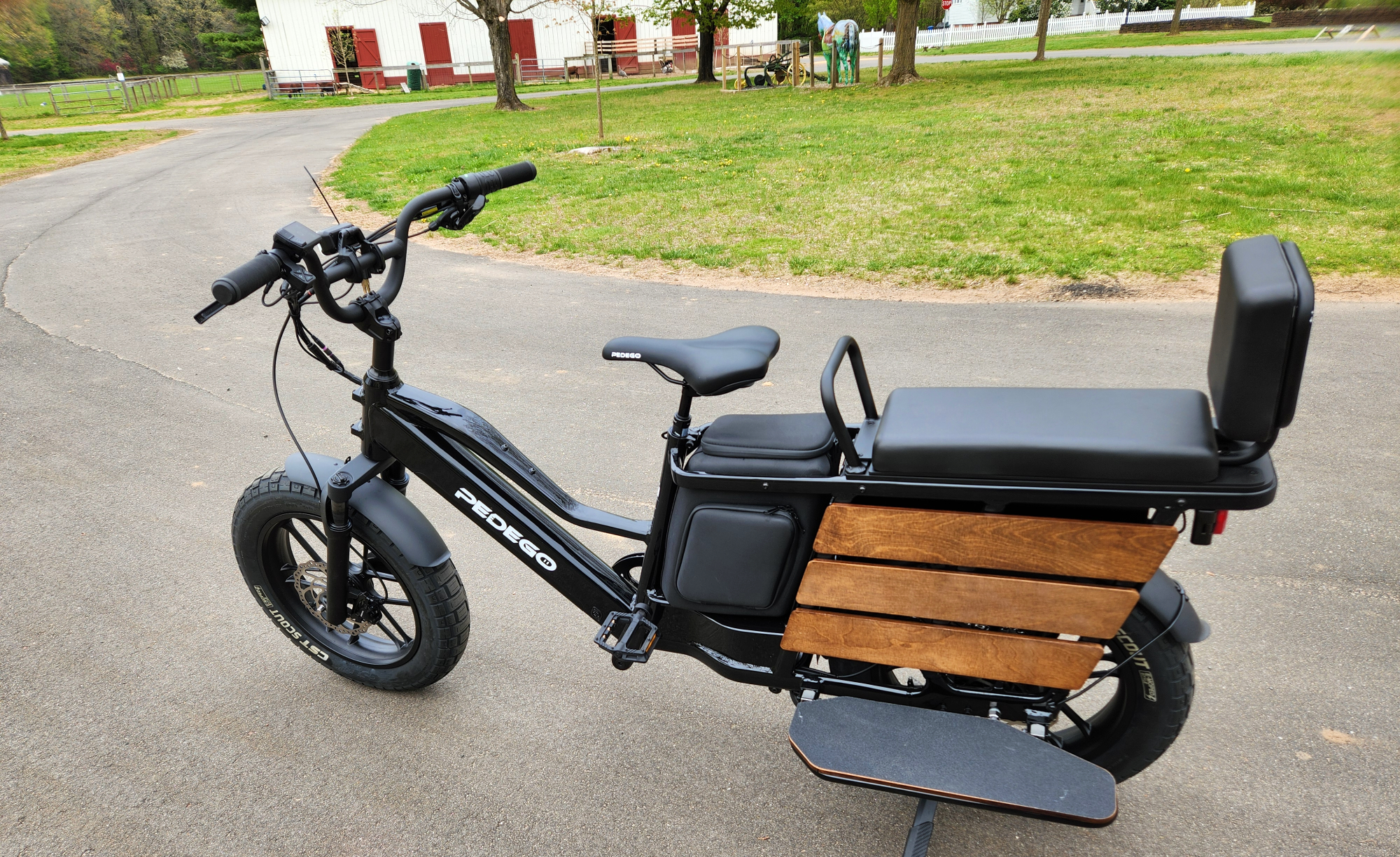 Pedego Cargo vue du côté gauche des sièges, du rangement et des commandes au guidon.