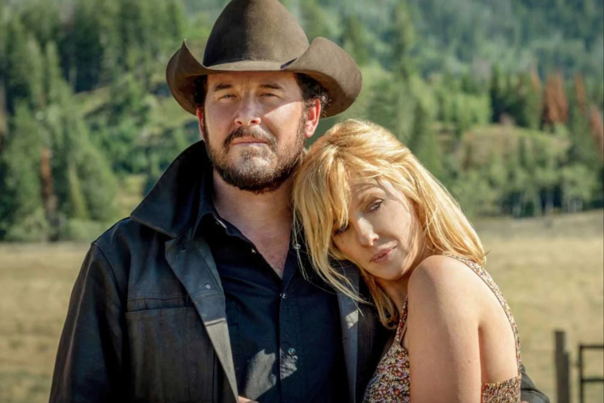 A woman puts her head against a man's shoulder in Yellowstone.