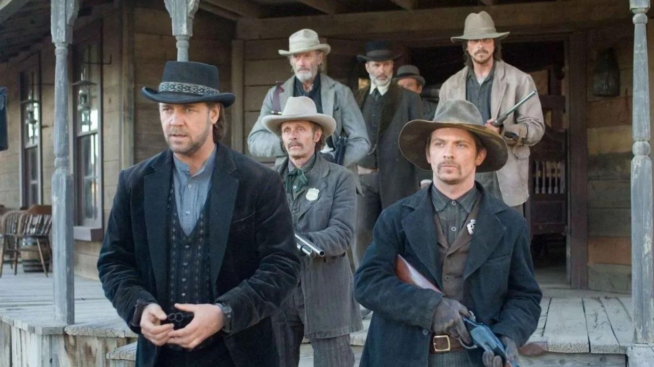 Russell Crowe como Ben Wade caminando frente a un grupo de hombres en 3:10 to Yuma de 2007.