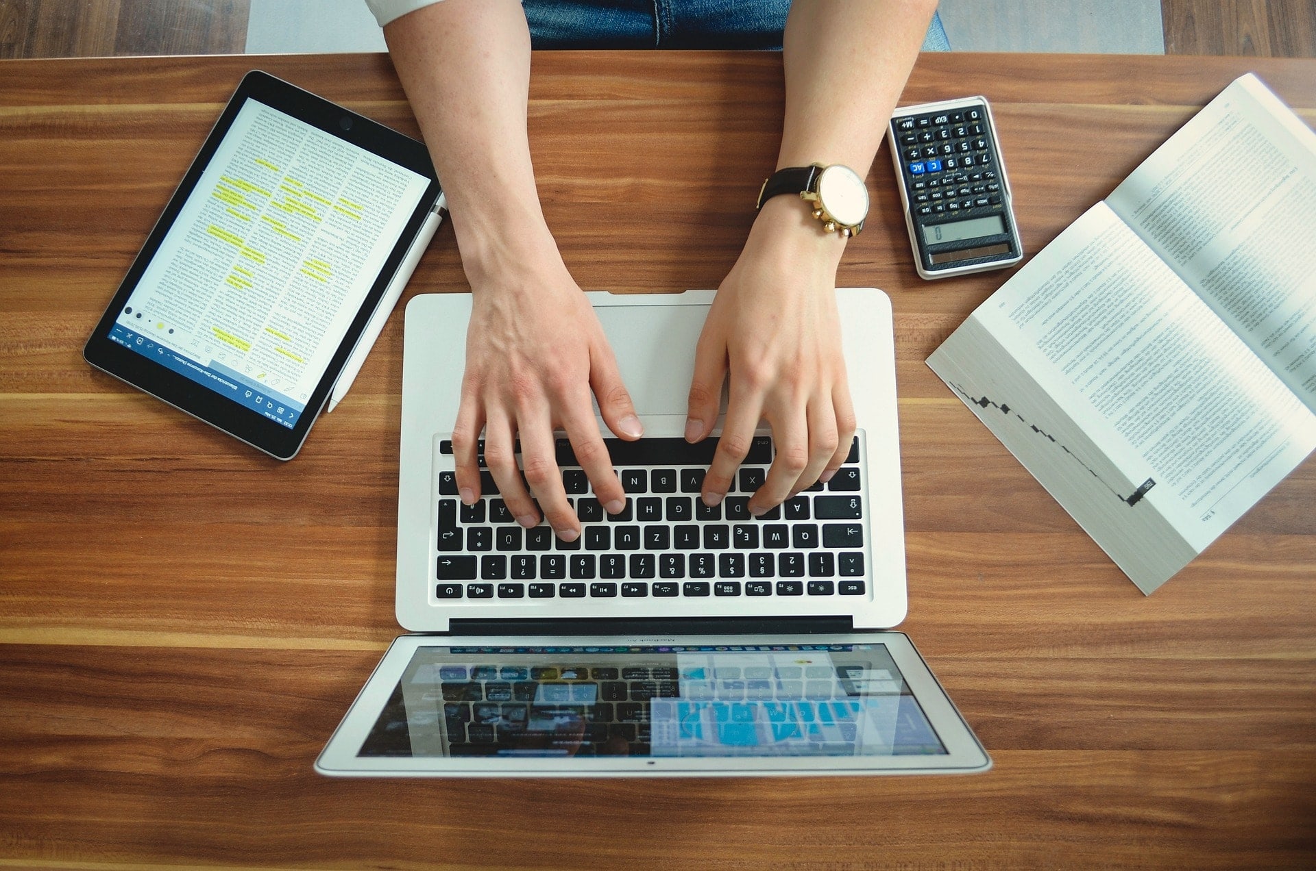 Étudiant tapant sur un ordinateur portable à un bureau.