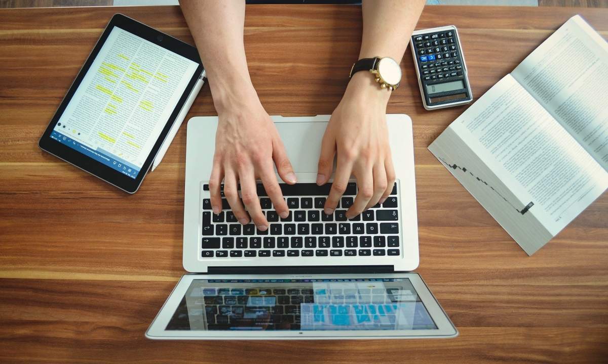 Student typing on a laptop at a desk.