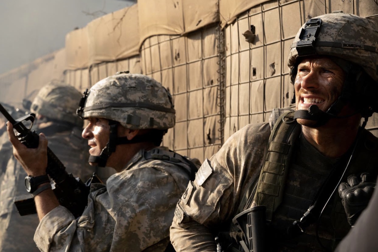 Deux soldats regardent, dos au mur.