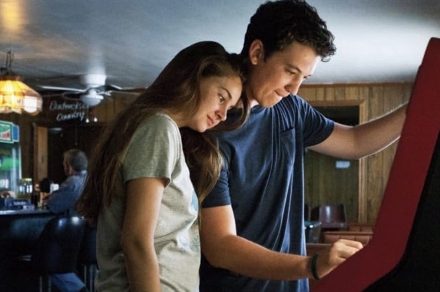 A man and woman stare at a jukebox.