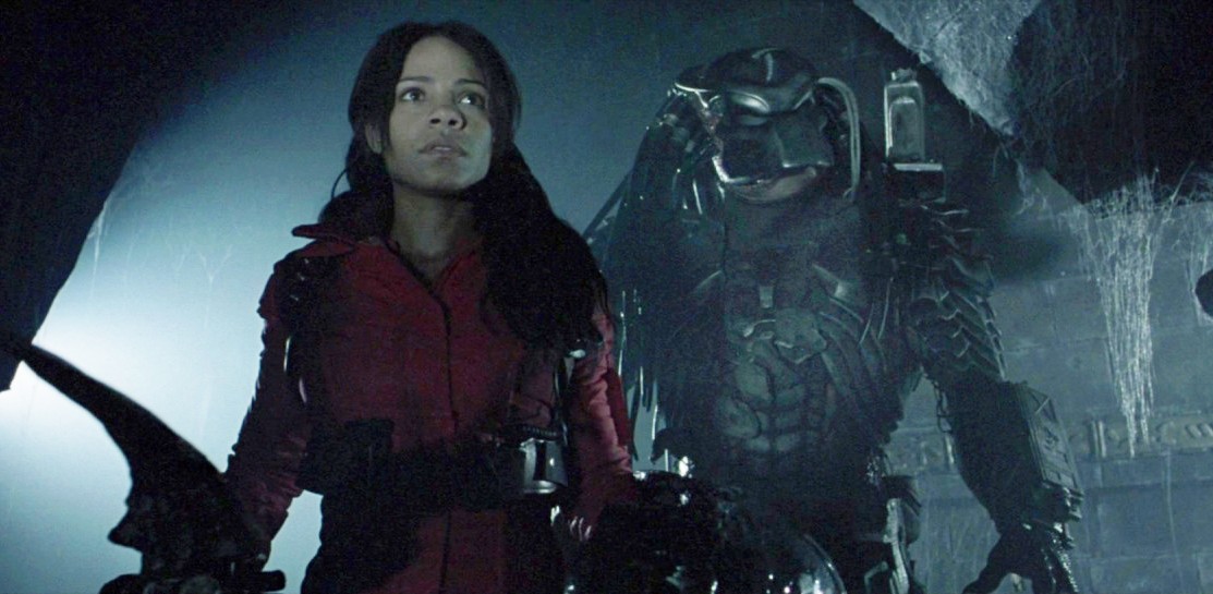 Una mujer junto a un Depredador en Alien vs. Predator.