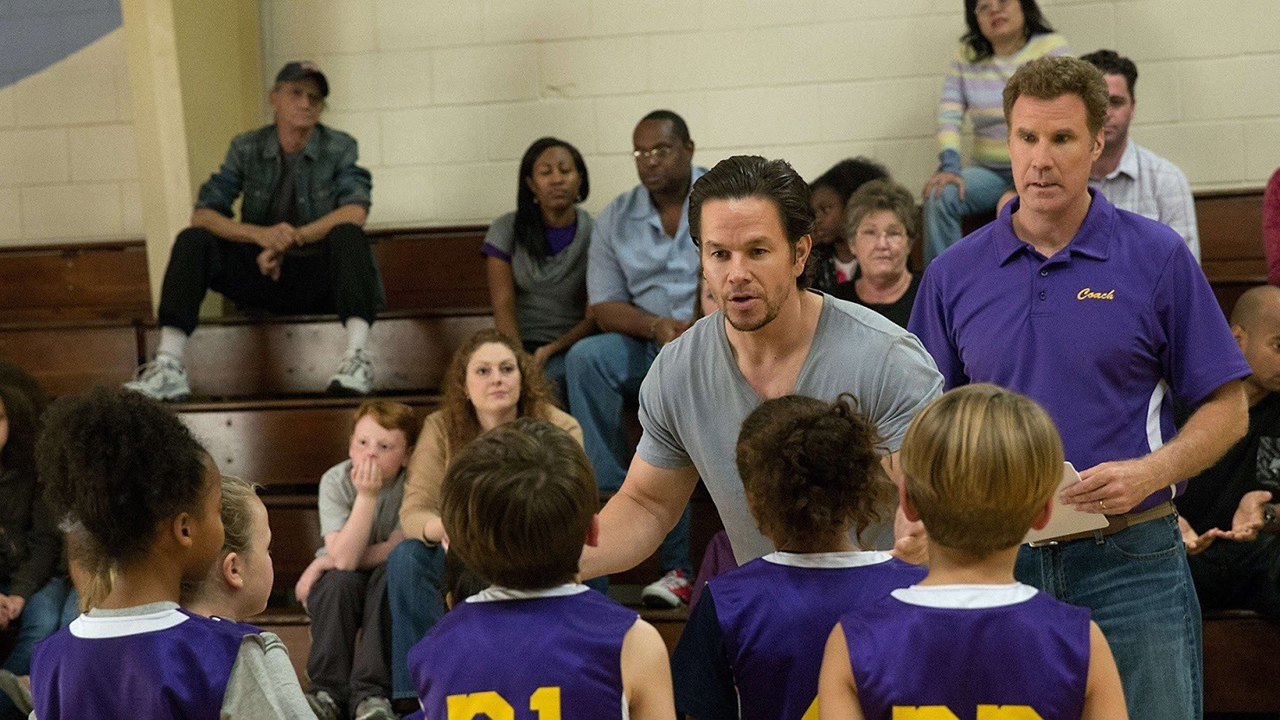 Mark Wahlberg parle à un groupe d'enfants jouant au basket-ball sous le regard de Will Ferrell dans une scène de Daddy's Home.