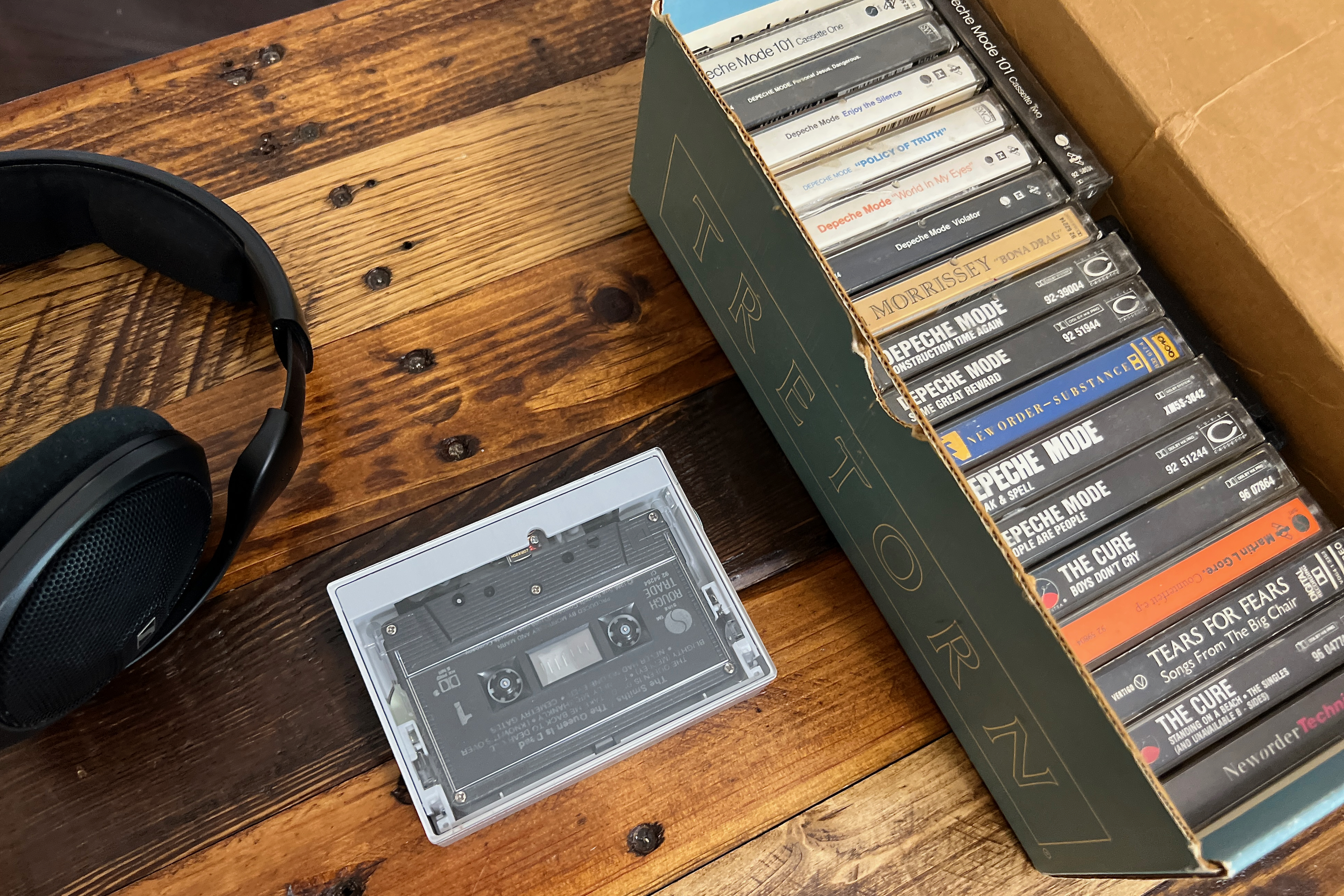 La cassette portable Fiio CP13 joue à côté d'une boîte à chaussures Tretorn remplie de cassettes.