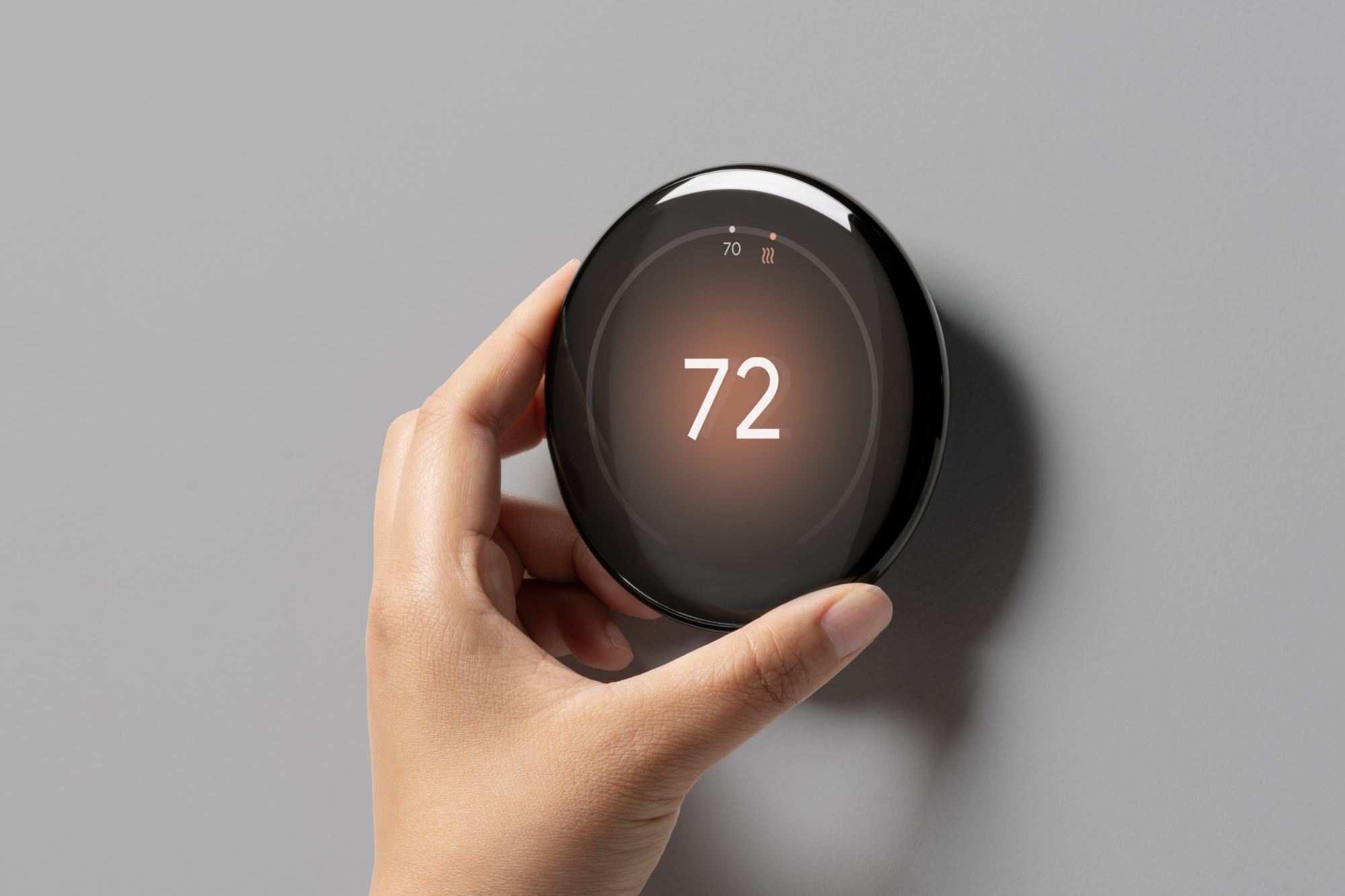 Jemand passt die Temperatur am Google Nest Learning Thermostat (4. Generation) an.