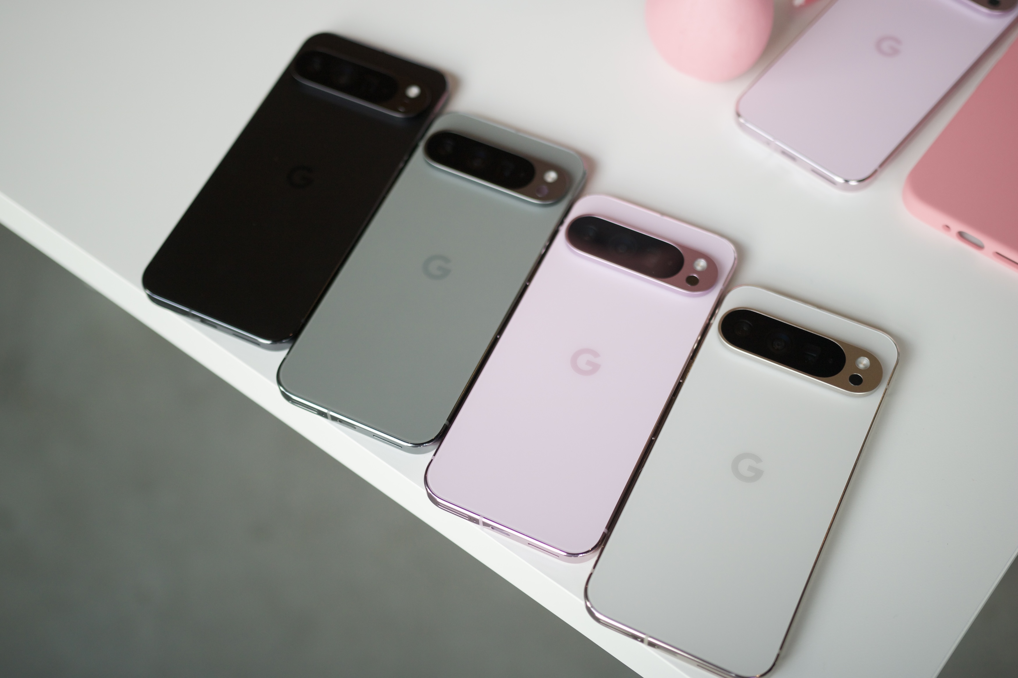 All four colors of the Google Pixel 9 Pro XL laying next to each other on a white table.