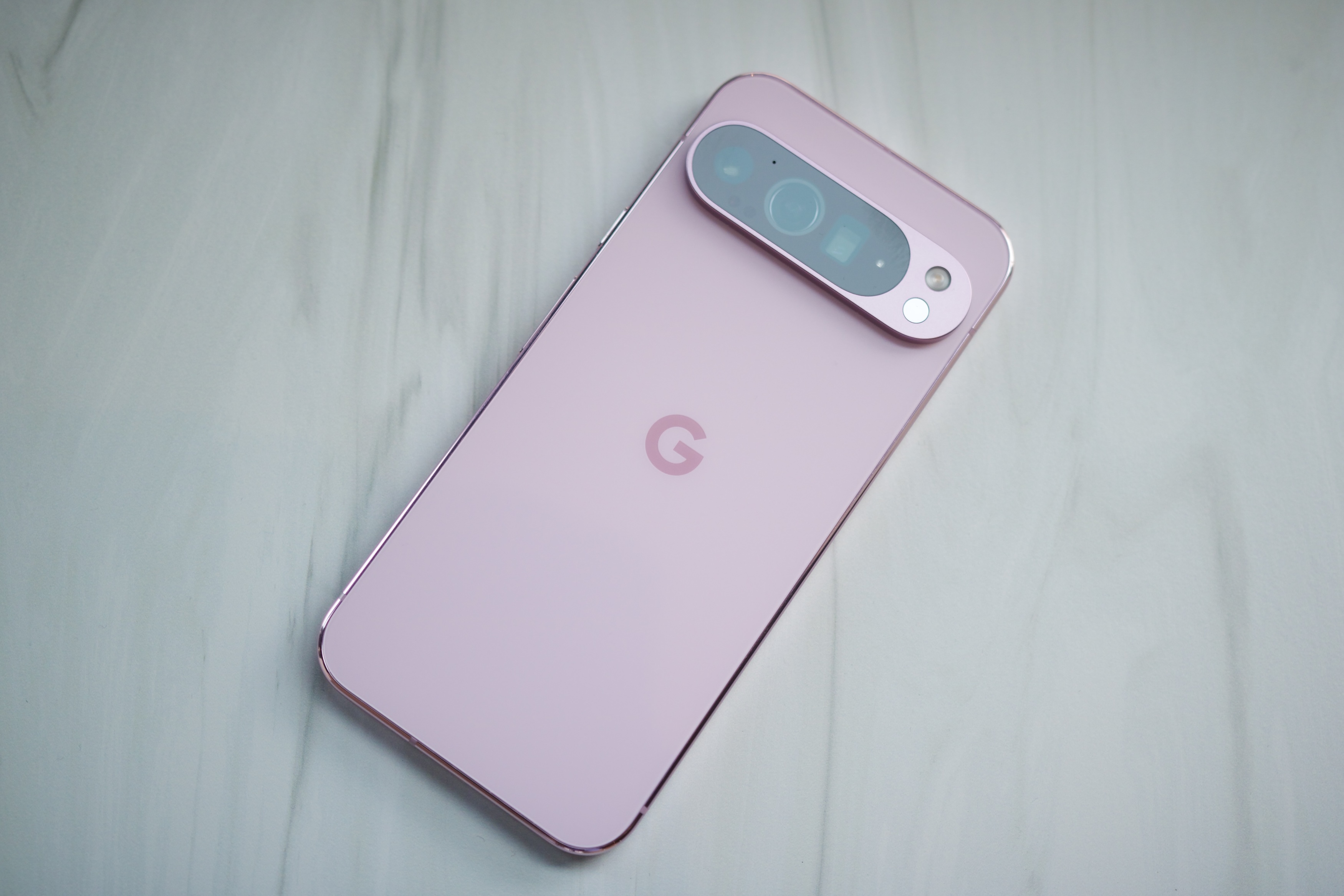 A pink Google Pixel 9 Pro XL lies there.