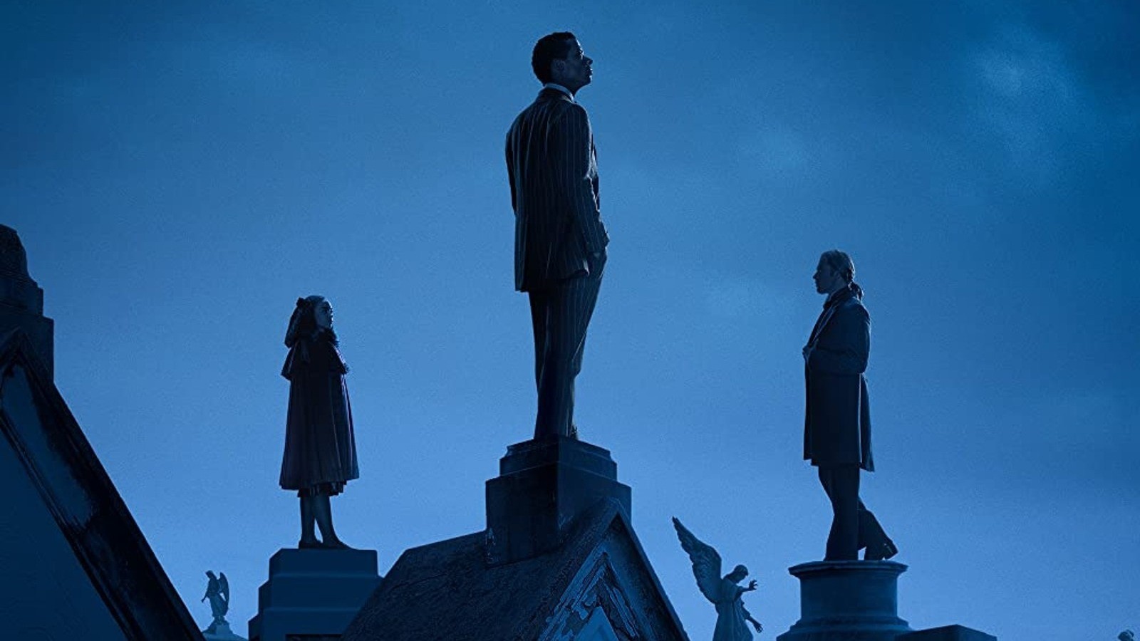 Three people stand on a roof in Interview with the Vampire.