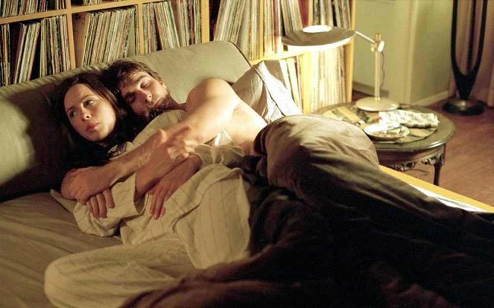 A man holds a woman in bed in Laurel Canyon.