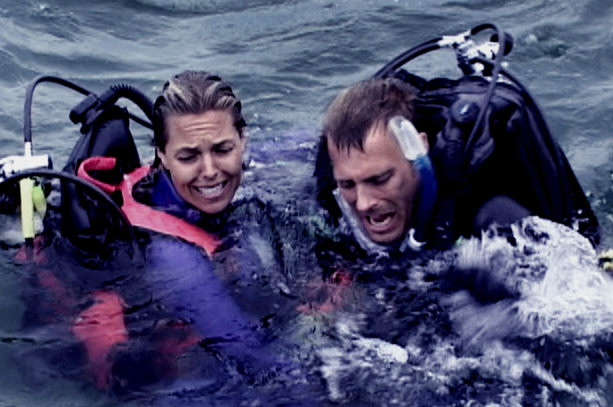 Un homme et une femme regardent quelque chose dans l’eau dans Open Water.