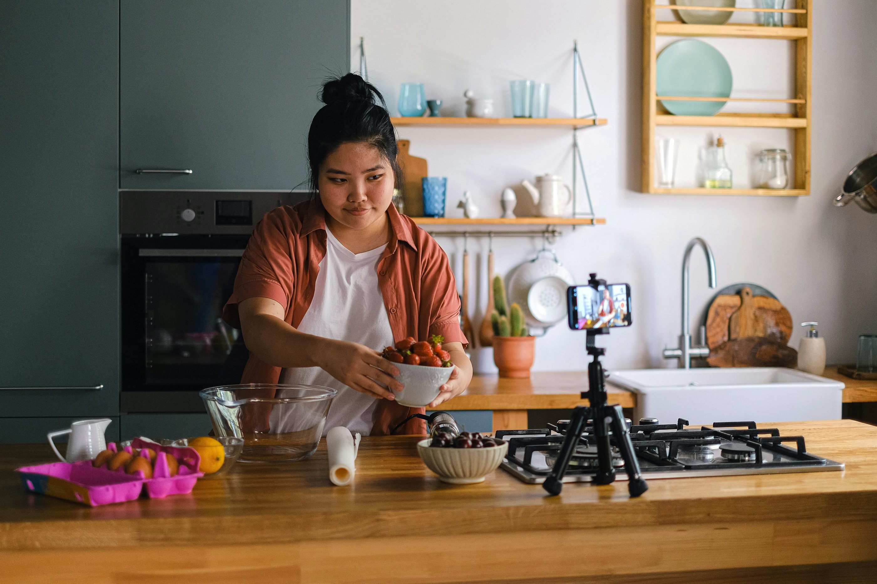 un créateur de contenu enregistrant quelque chose dans la cuisine avec un bol de nourriture