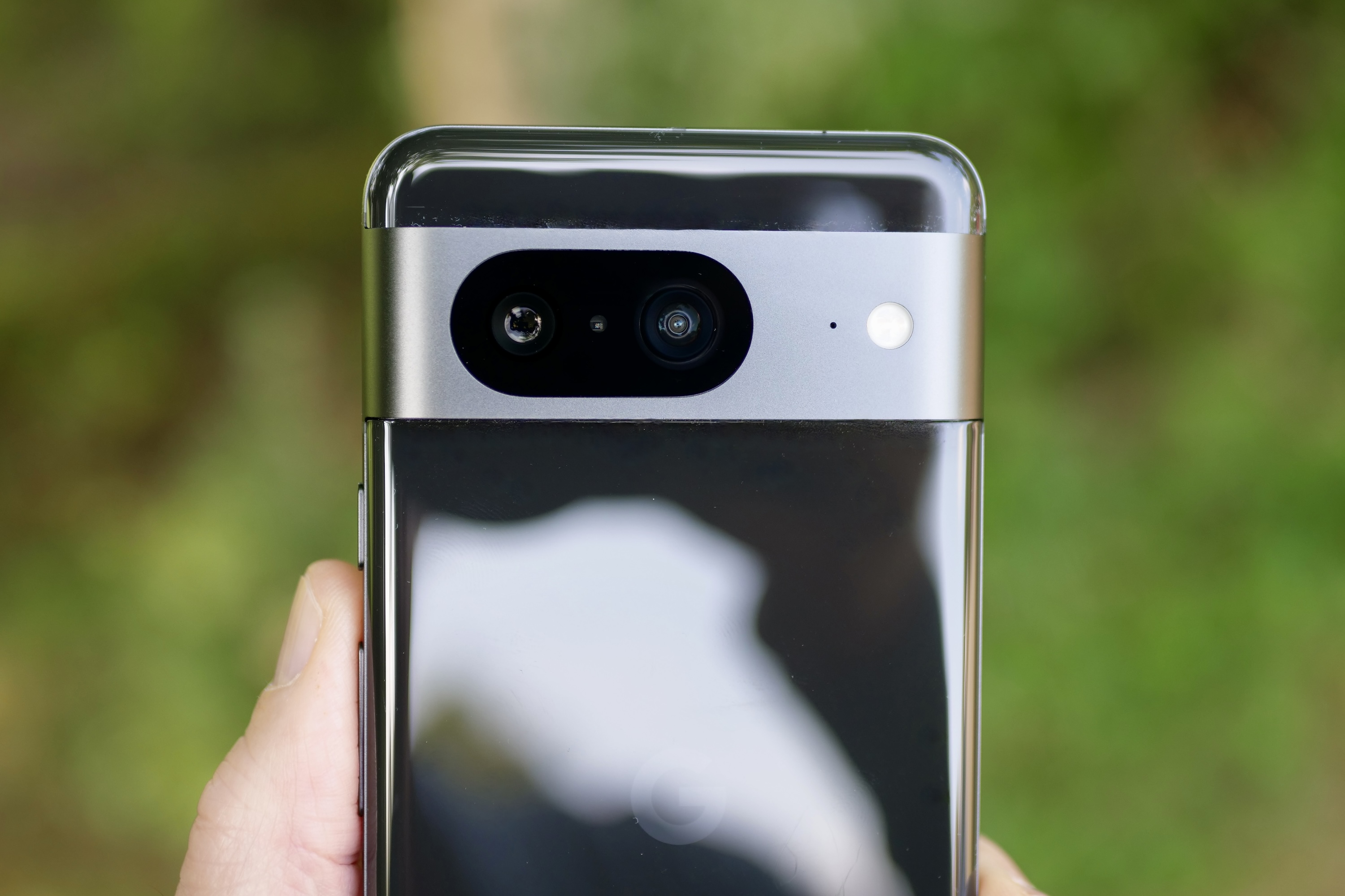 A person holding the Google Pixel 8, showing the camera.