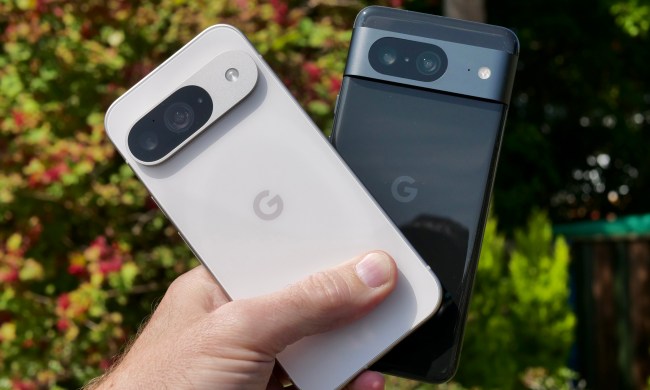 A person holding the Google Pixel 9 and Google Pixel 8.