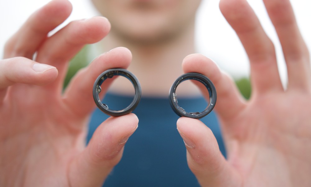 Someone holding the Samsung Galaxy Ring and the Oura Ring.