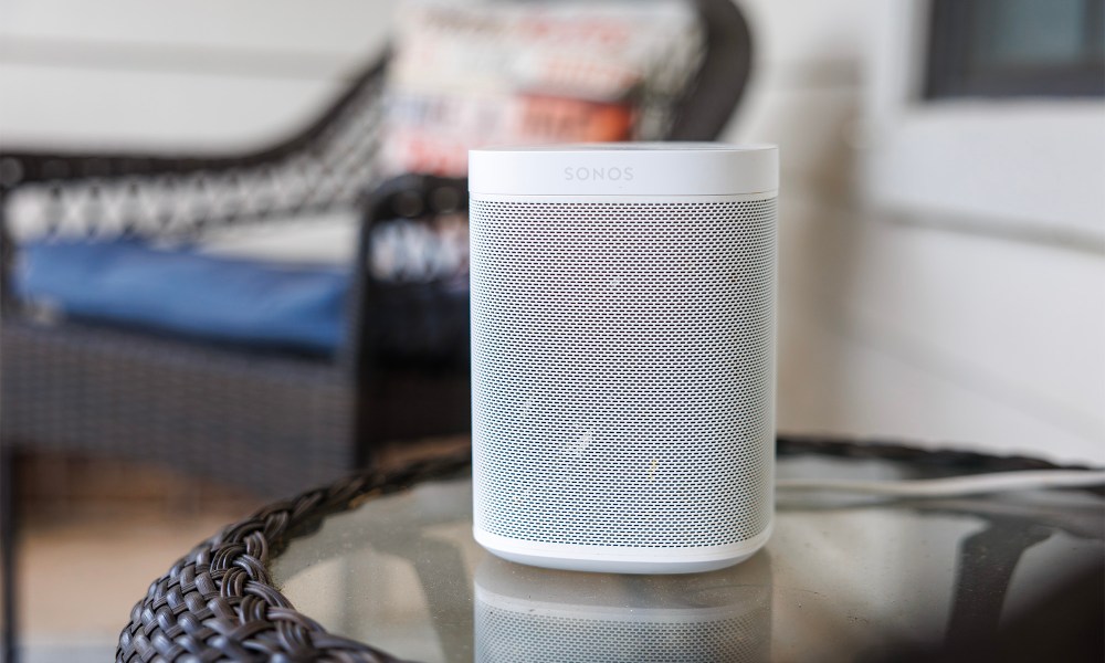 A Sonos One speaker sitting on an outdoor table.