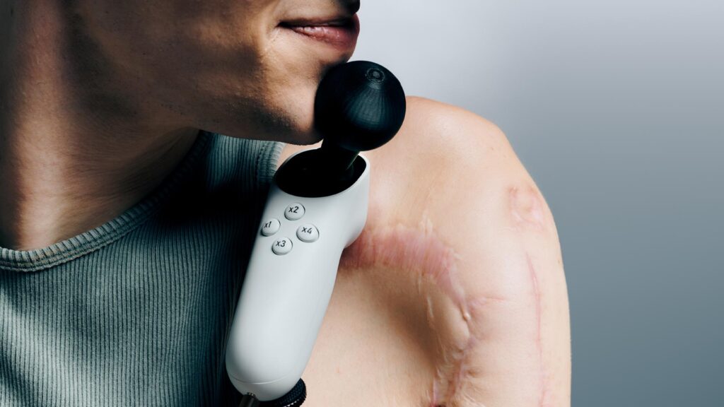 An Xbox Adaptive Joystick sits on a person's shoulder.