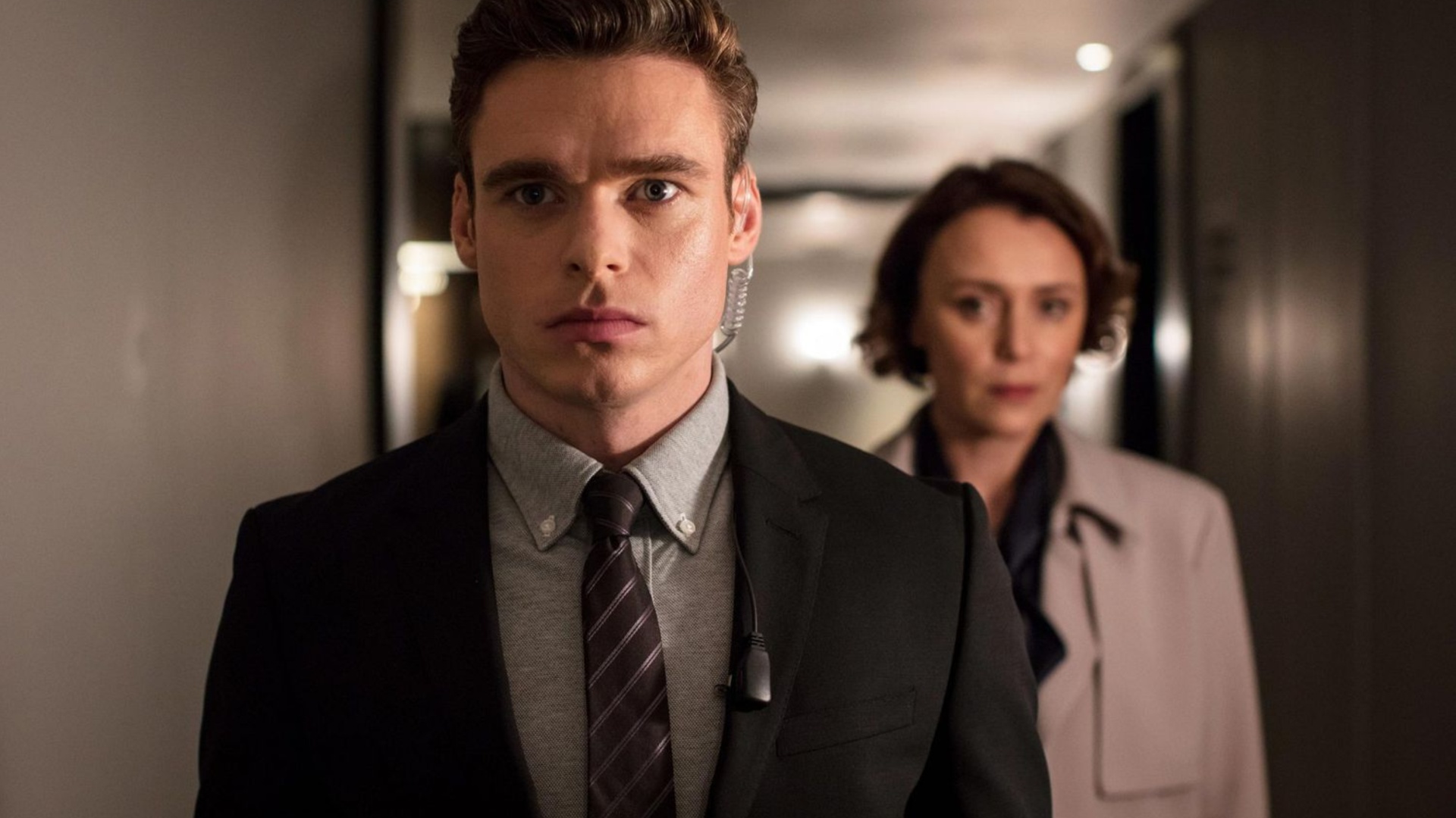 Richard Madden como David Budd escoltando o Ministro do Interior britânico na guarda-costas.