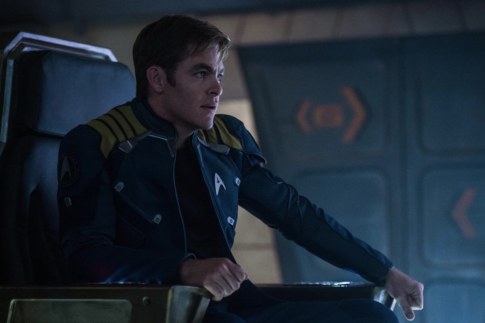 Chris Pine se senta na cadeira do capitão e fica olhando.