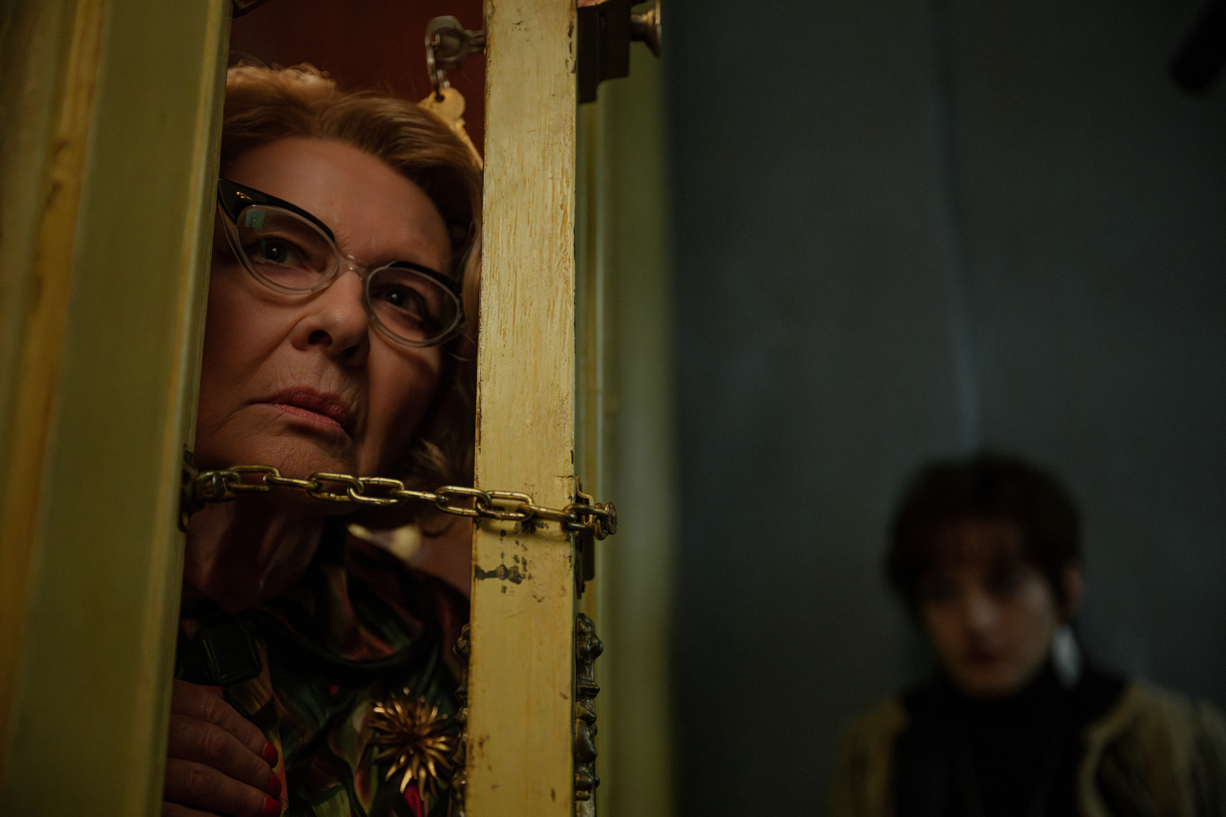 Dianne Wiest, Daire 7A'daki aralık kapıdan bakıyor.