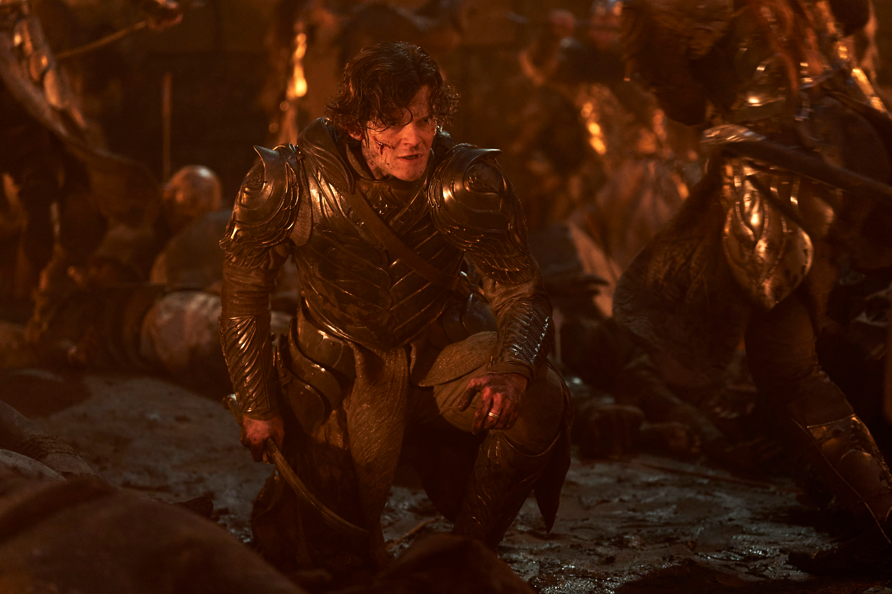 Elrond kneels on a battlefield in The Lord of the Rings: The Rings of Power season 2.