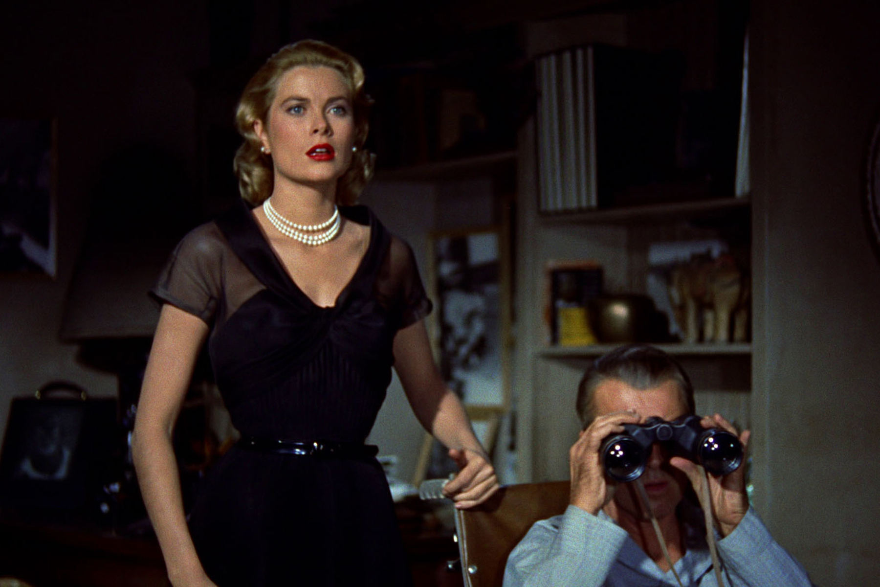 Grace Kelly stands next to Jimmy Stewart in Rear Window.