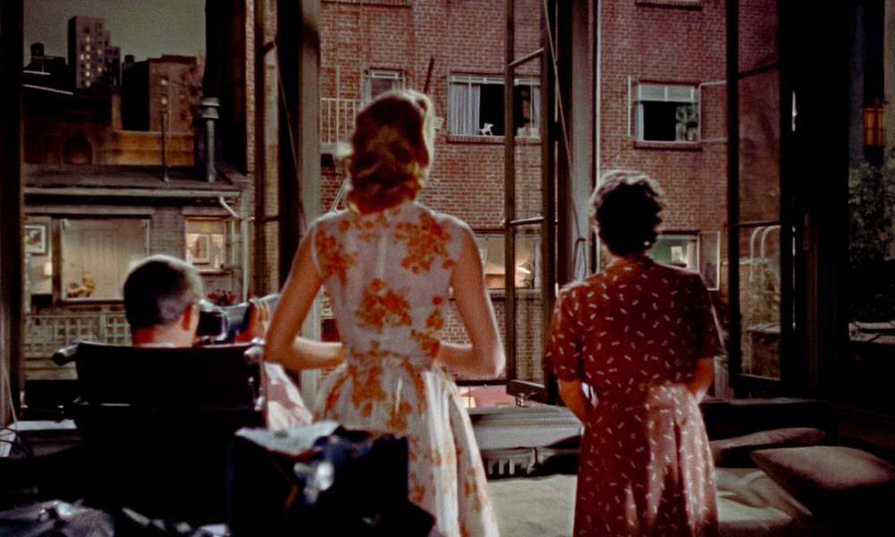 Jimmy Stewart, Grace Kelly, and Thelma Ritter look out an apartment window together in Rear Window.