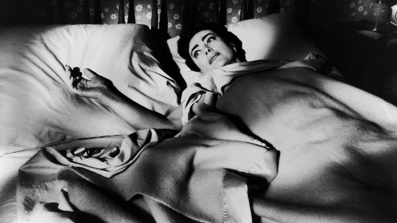 Joan Crawford seule au lit dans Autumn Leaves.