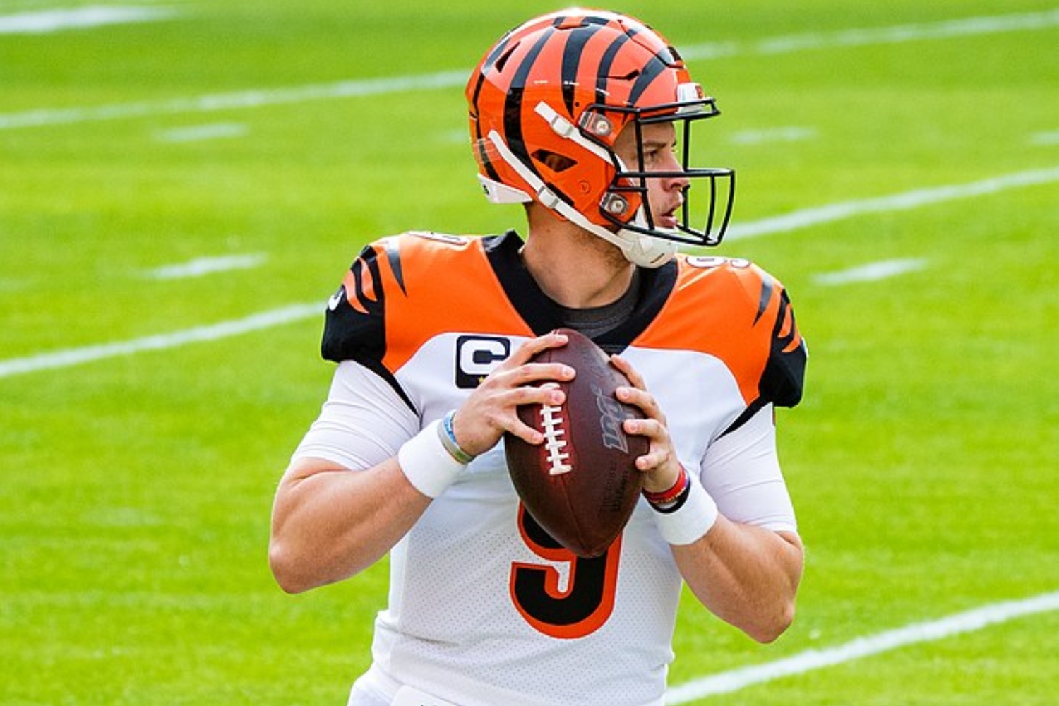 Joe Burrow sostiene una pelota de fútbol y se prepara para lanzar.