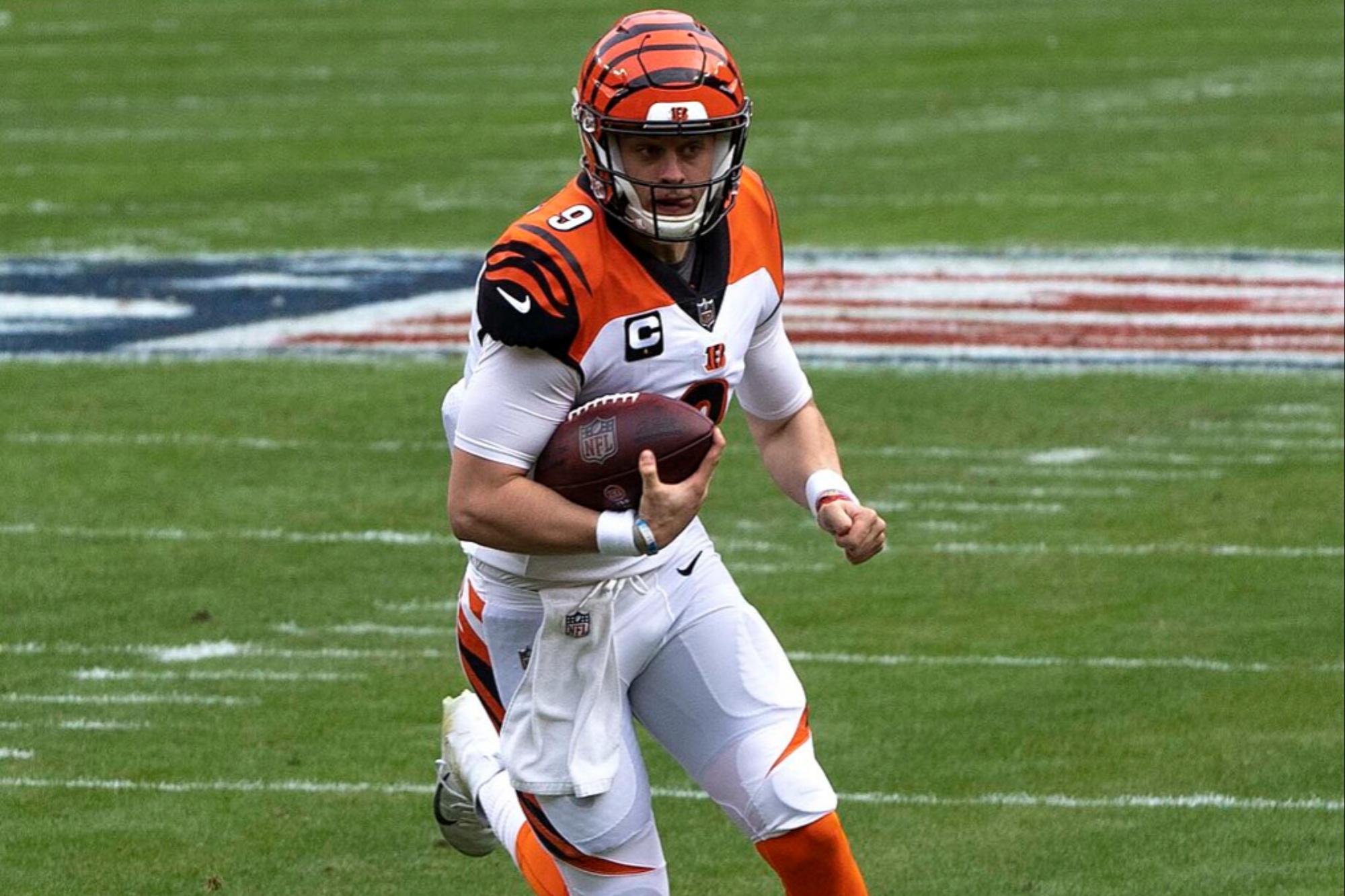 Joe Burrow holds the football and runs.