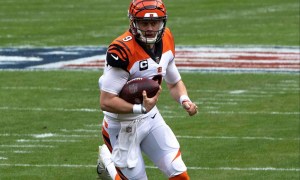 Joe Burrow holds the football and runs.