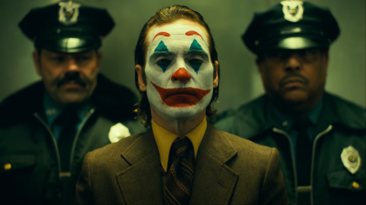 O Coringa fica na frente de dois policiais em um elevador em "Joker: Folie à Deux".