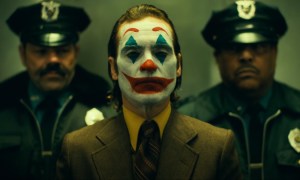 The Joker stands in front of two cops in an elevator in "Joker: Folie à Deux."