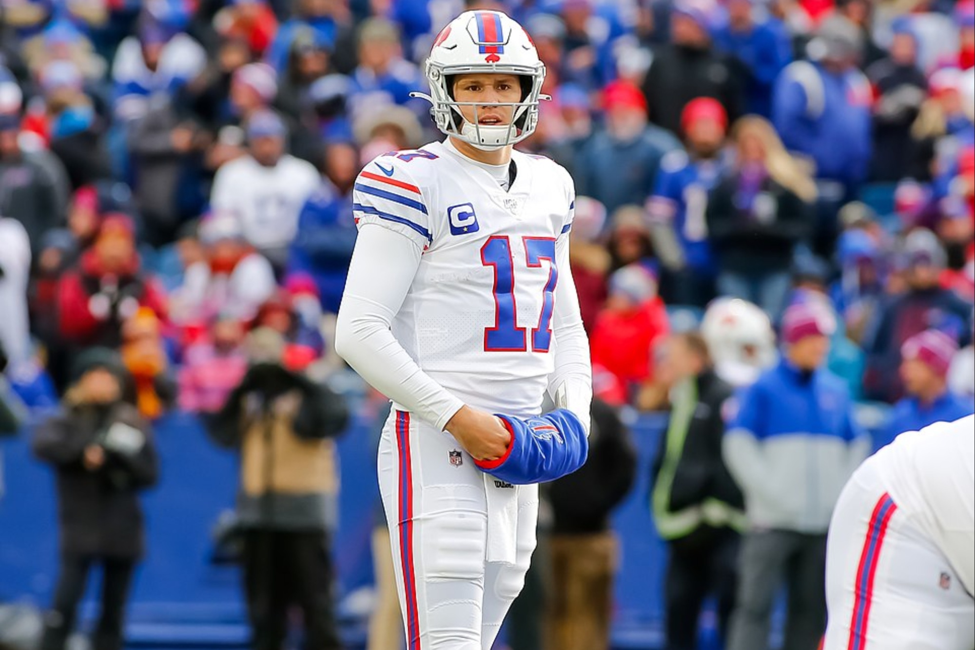 Josh Allen puts his hands in a hand warmer on the field.