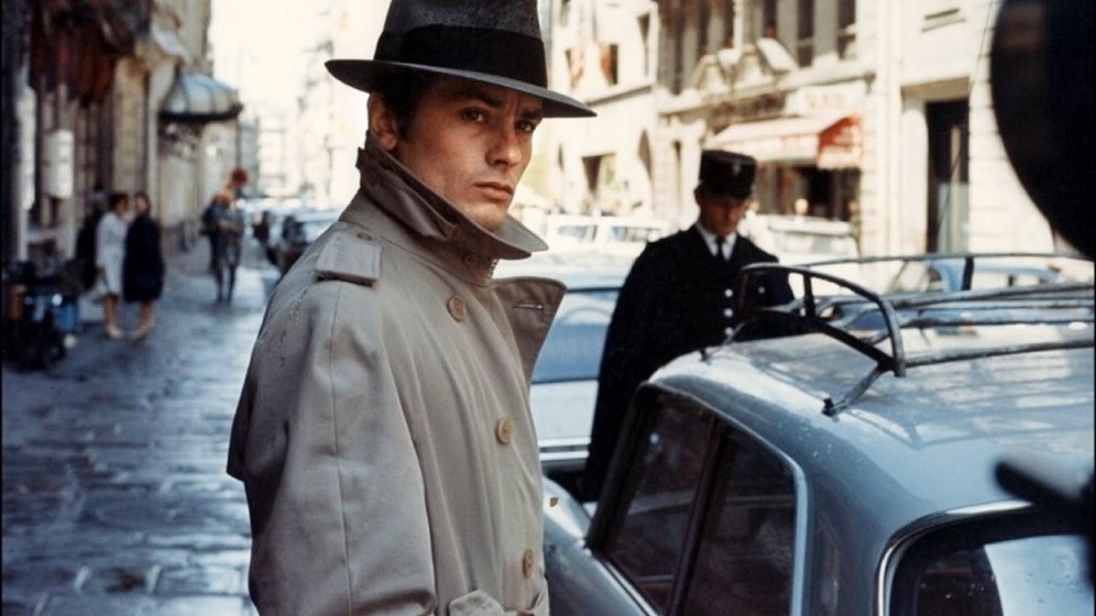 In Le Samourai a man stands next to a car.