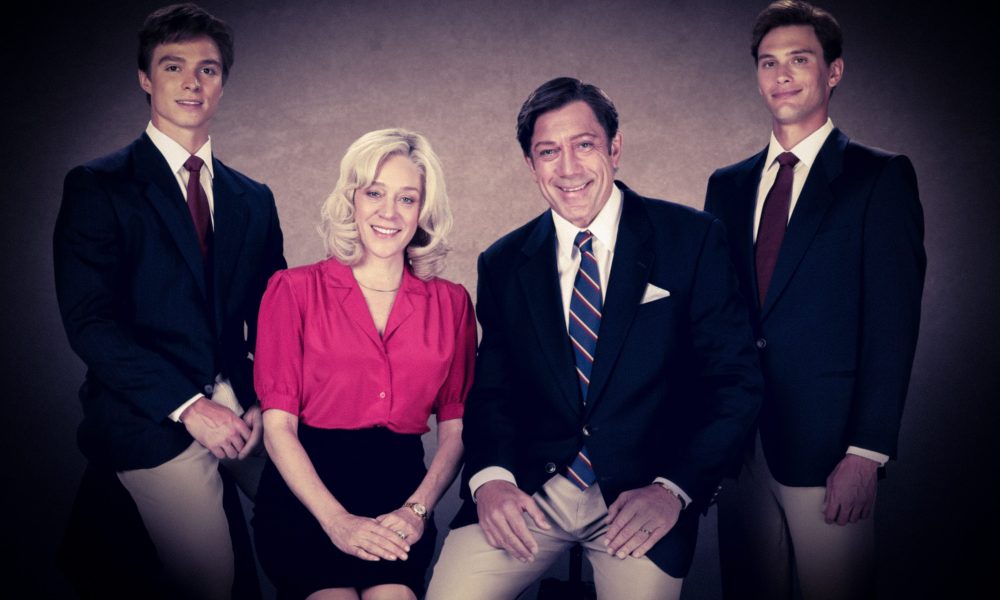 A family of two boys, a mom, and dad pose for a photo.