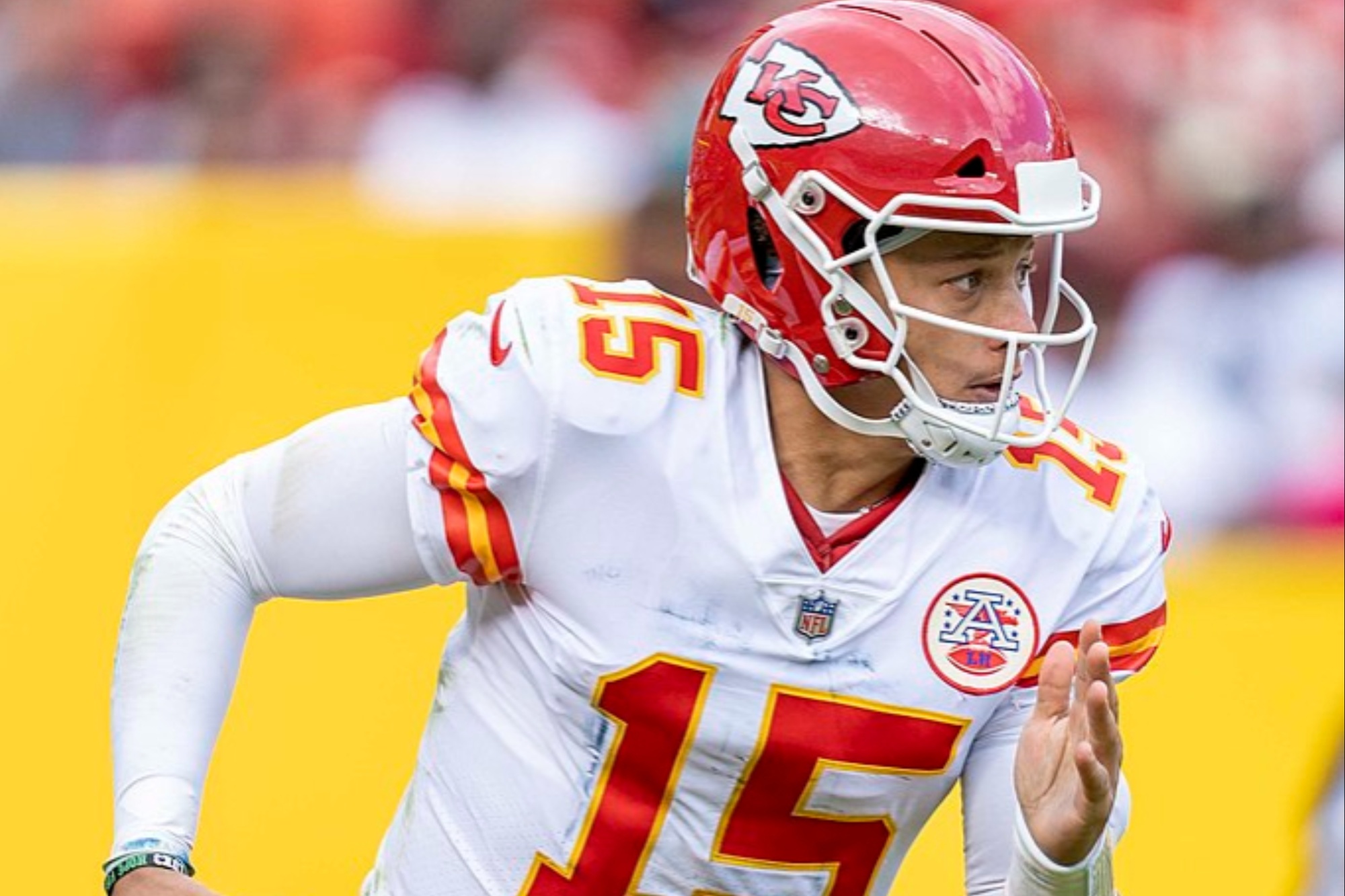 Patrick Mahomes corre com uma bola em campo.