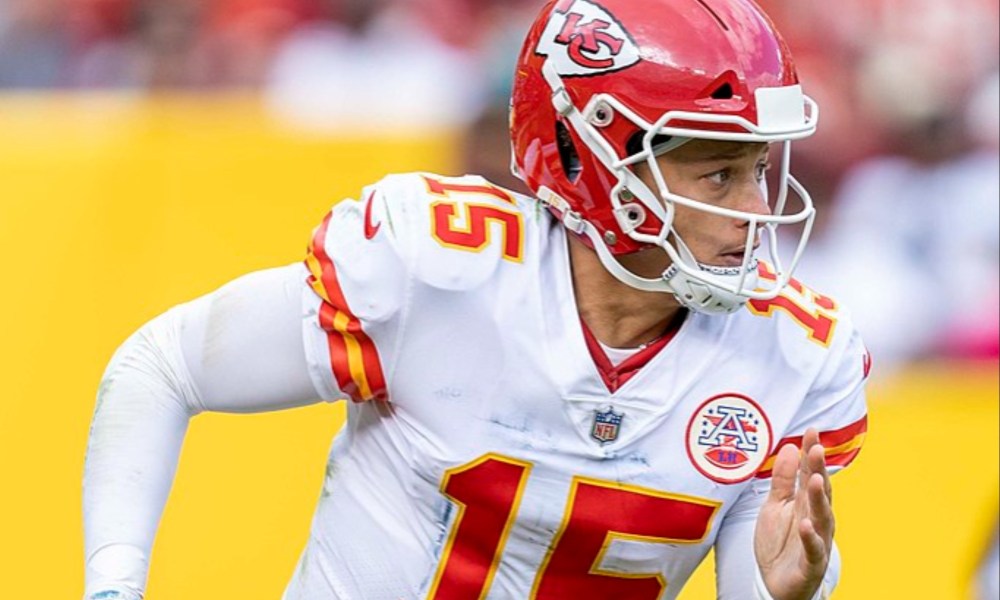 Patrick Mahomes runs with a ball on the field.