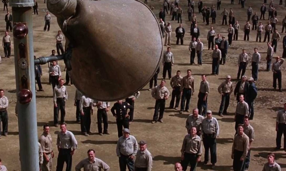 Prisoners stand in a prison yard in The Shawshank Redemption.