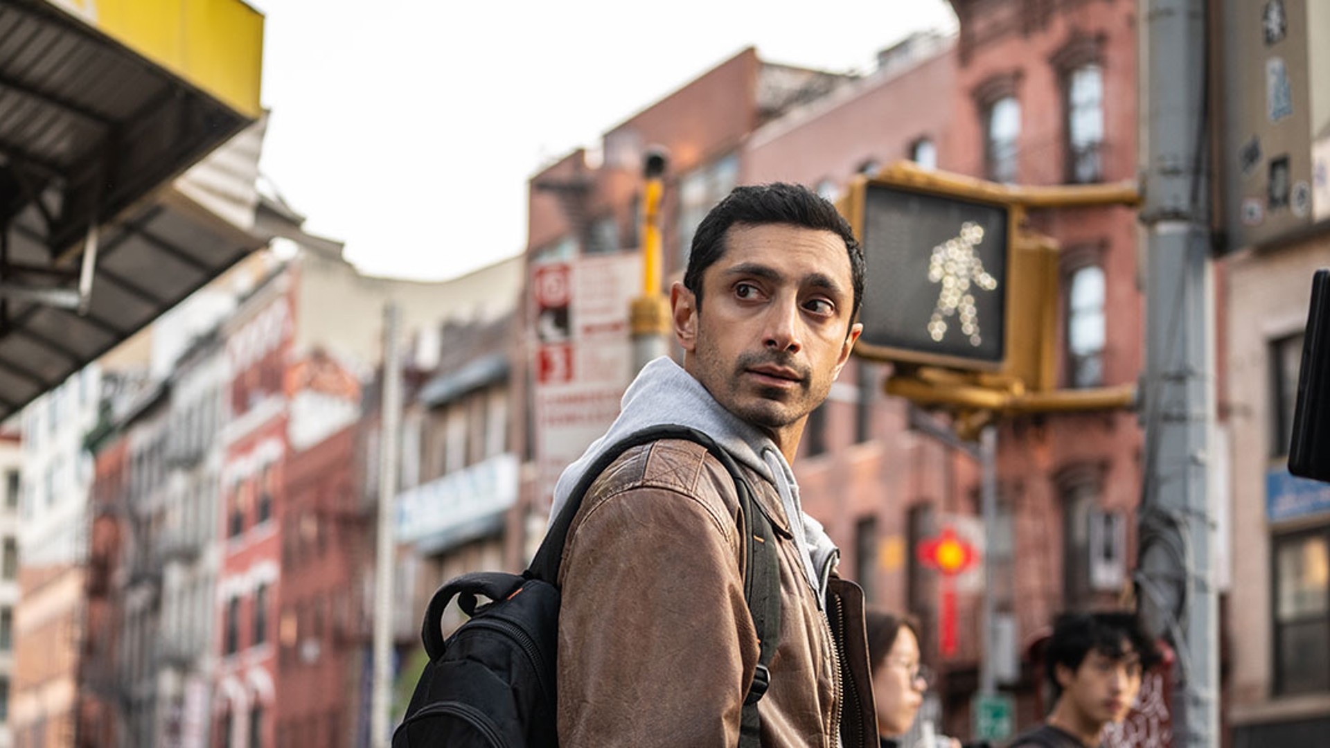 Riz Ahmed olha por cima do ombro em uma foto do filme Relay.