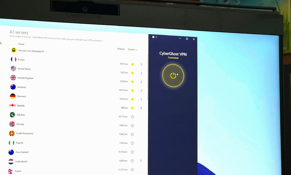 The CyberGhost VPN app is open and showing servers on a PC monitor.