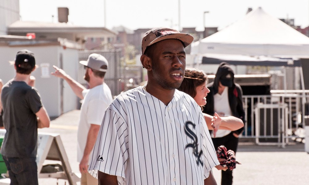 Tyler the Creator stands with a confused look on his face.