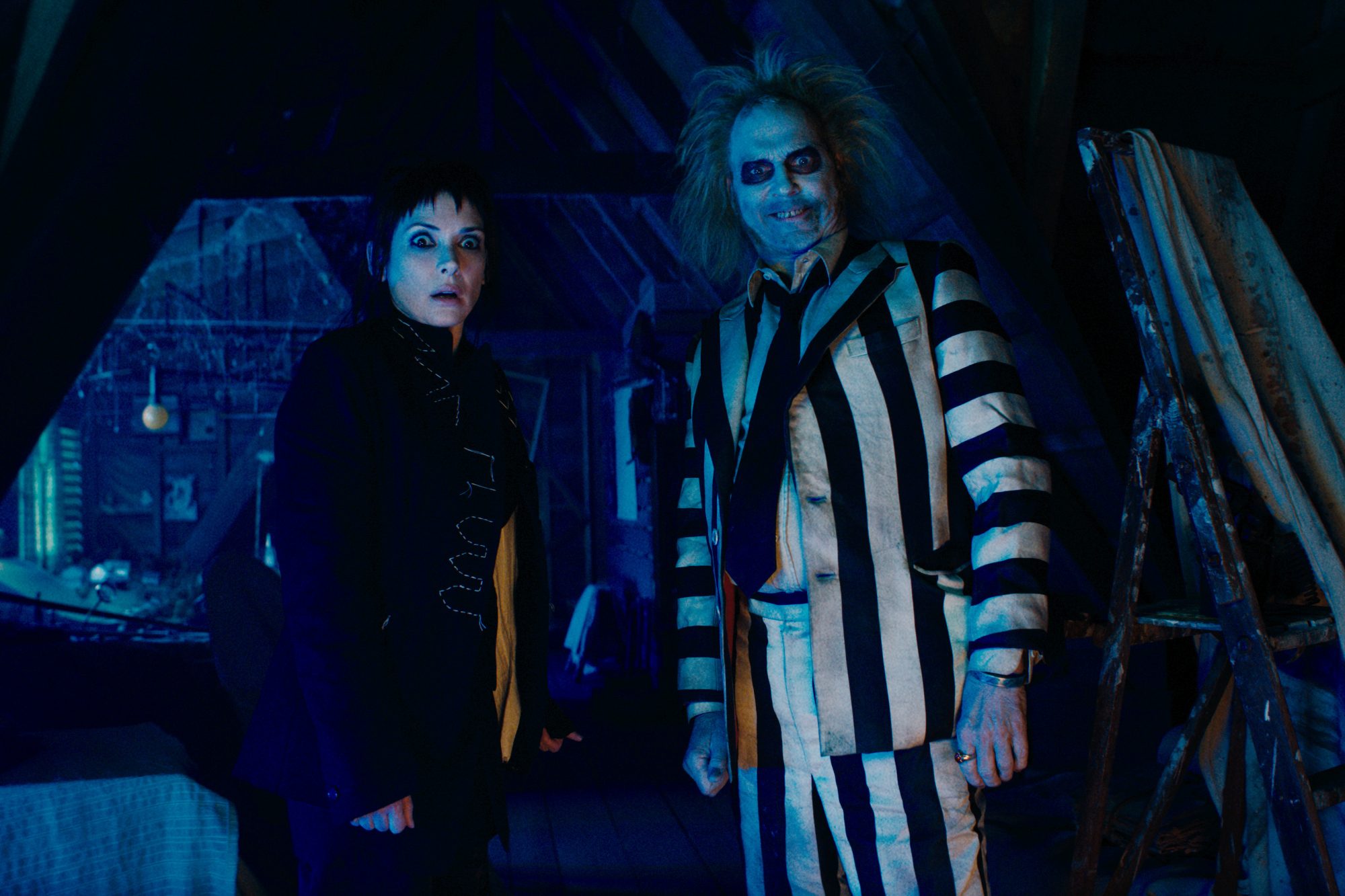 Winona Ryder stands next to Michael Keaton in Beetlejuice Beetlejuice.