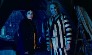 Winona Ryder stands next to Michael Keaton in Beetlejuice Beetlejuice.