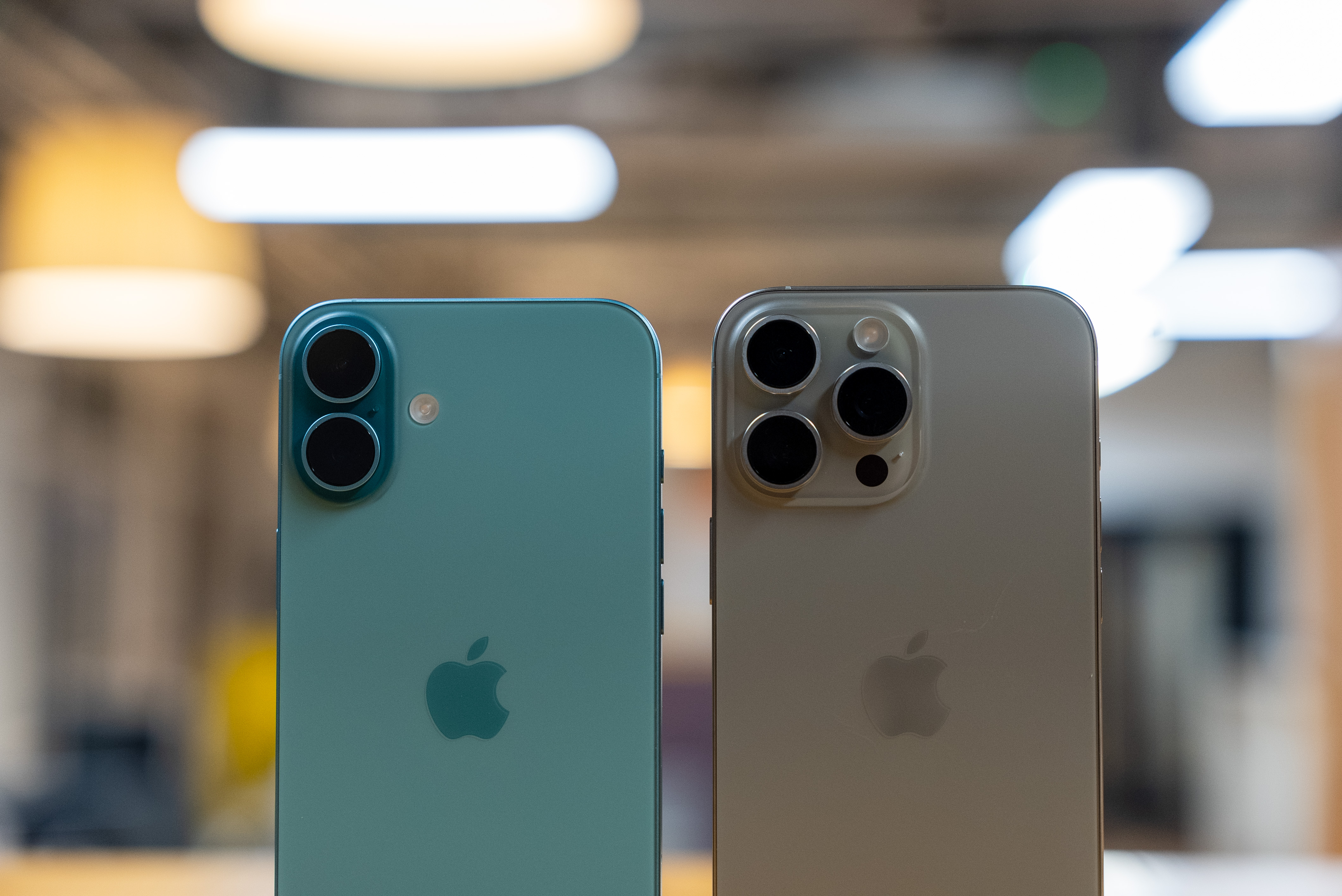 iPhone 16 Plus teal and iPhone 16 Pro Max natural titanium top half of rear