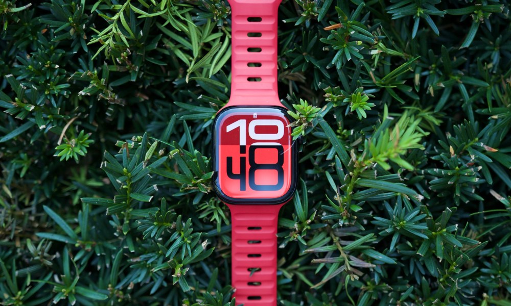 The Apple Watch Series 10 sitting on top of a green bush.